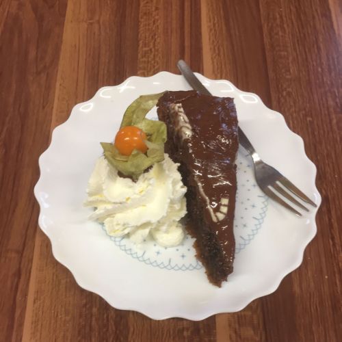 1 Stück Sachertorte mit Sahne auf Teller